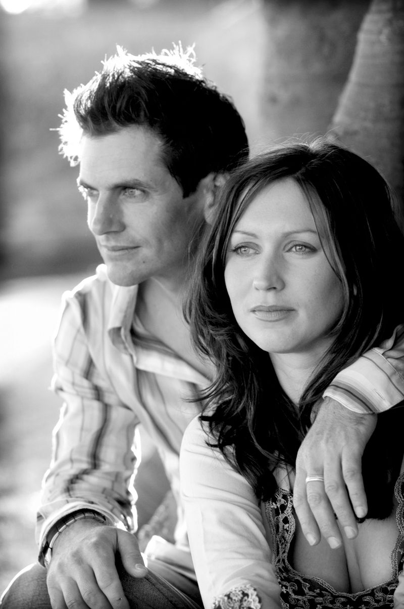 A couple standing together by the water, in black and white