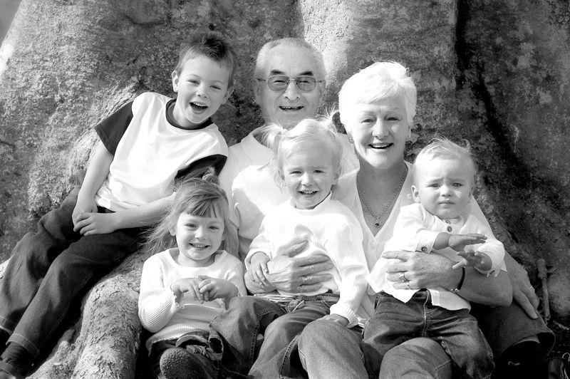 Three generations of one family seated together on the rocks