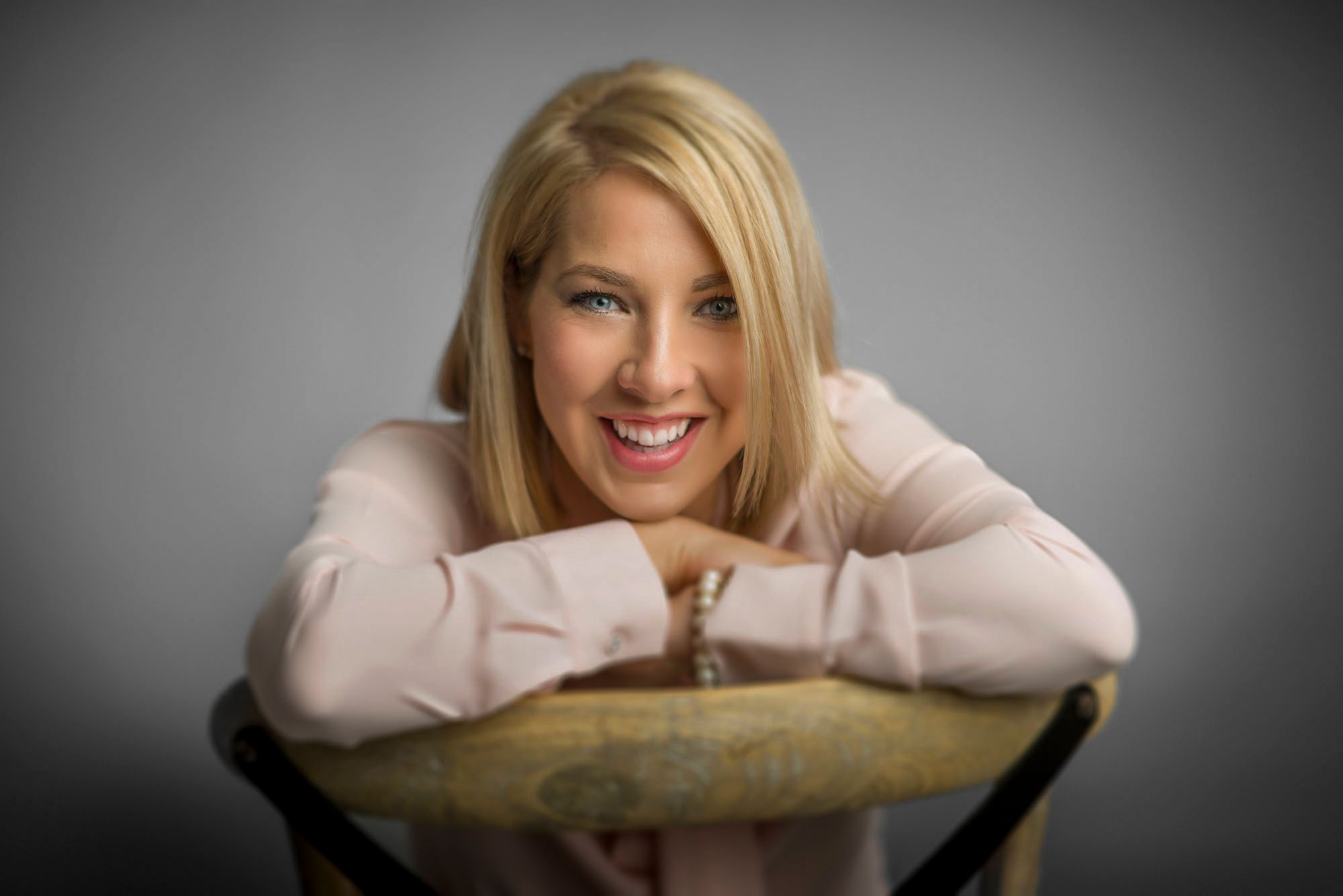 A woman leaning on the back of a chair, laughing